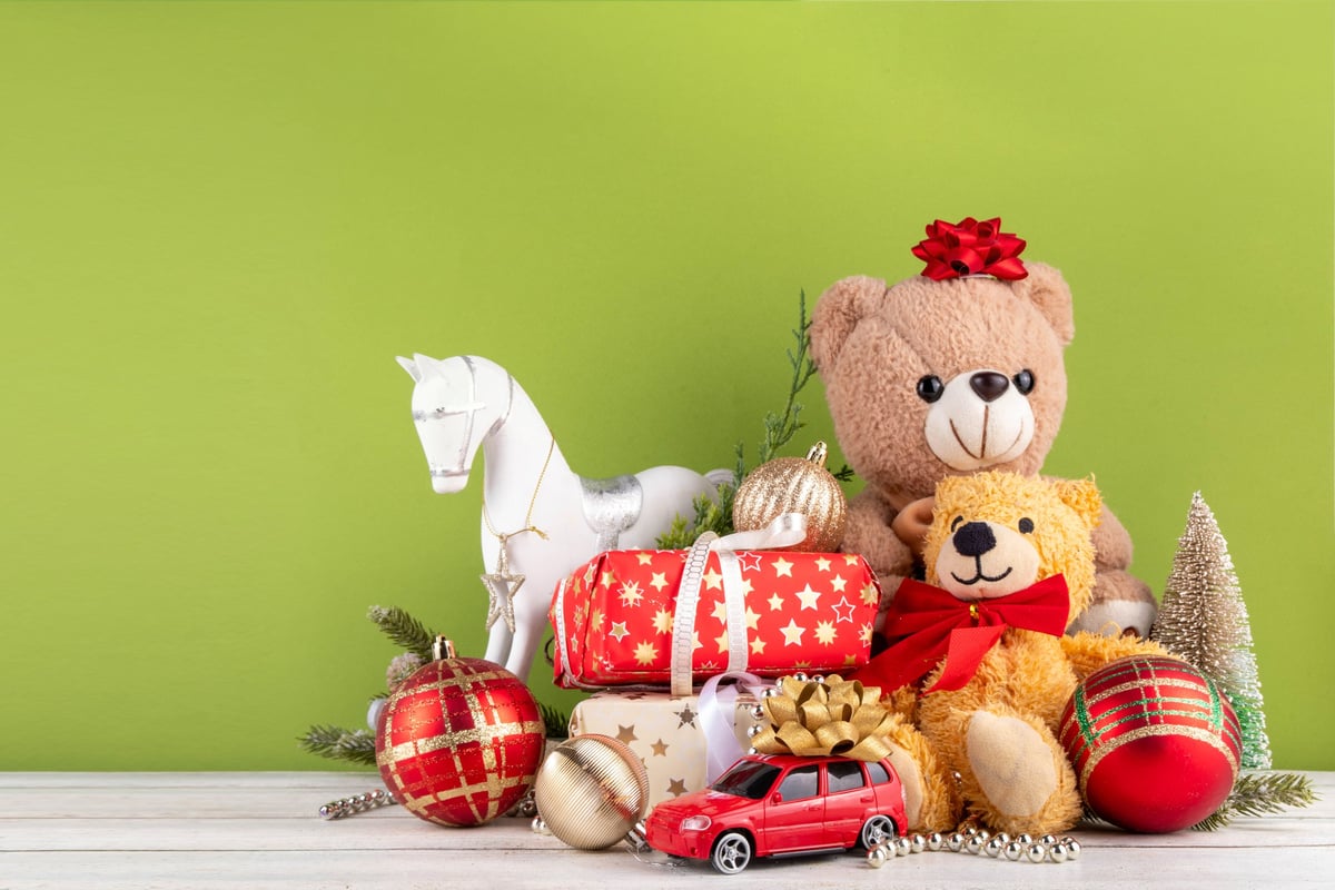 Teddy bears with gift wrapping under a Christmas tree